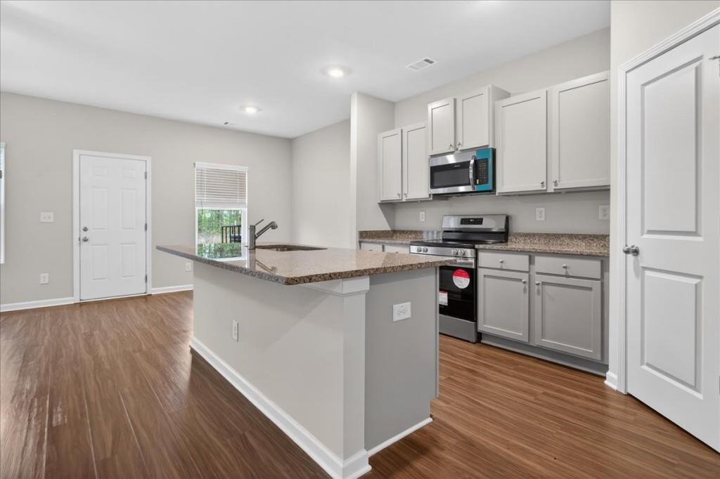 107 Brexley Drive Calhoun, GA 30701 - Photo 4 of 36 a kitchen with granite countertop a stove top oven and cabinets
