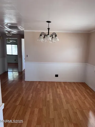 a view of a room with wooden floor and chandelier