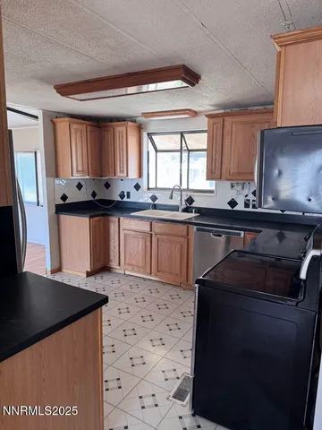 a kitchen with granite countertop a sink stainless steel appliances and cabinets