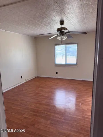 a view of a room with wooden floor and ceiling fan