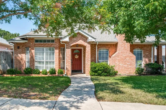 front view of a brick house with a yard