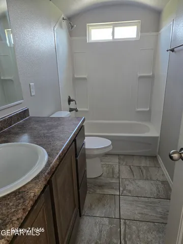 a bathroom with a granite countertop sink a toilet and bathtub