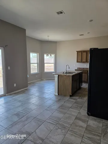 a living room with granite countertop furniture and a refrigerator