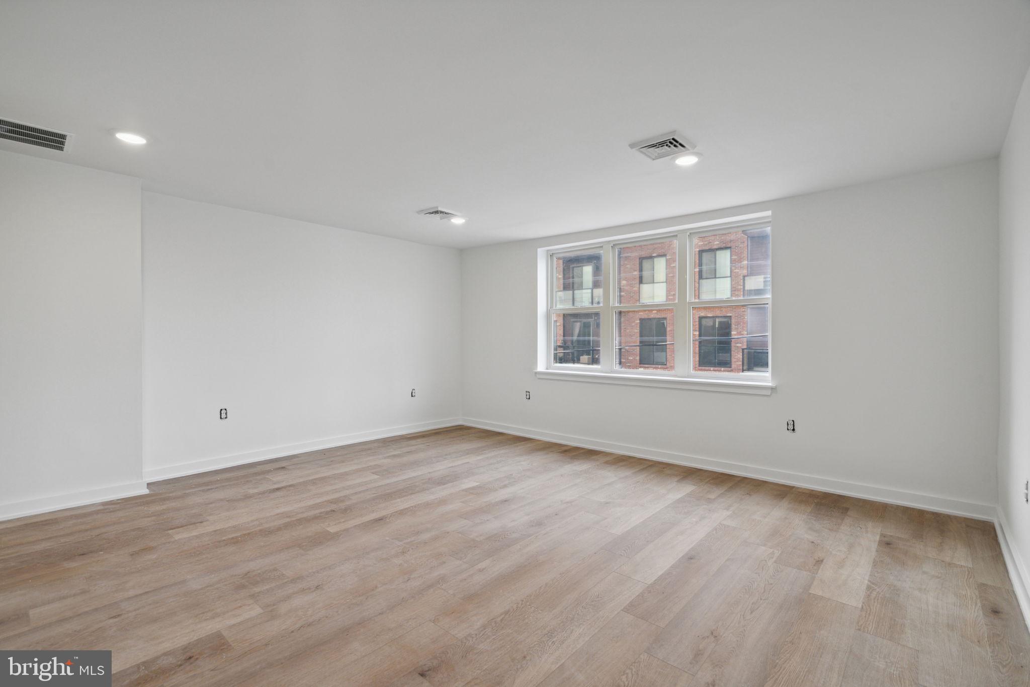 1873 Frankford Avenue, Unit 3F Philadelphia, PA 19125 - Photo 11 of 14 a view of an empty room with wooden floor and window
