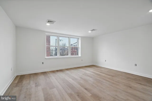 wooden floor in an empty room with a window