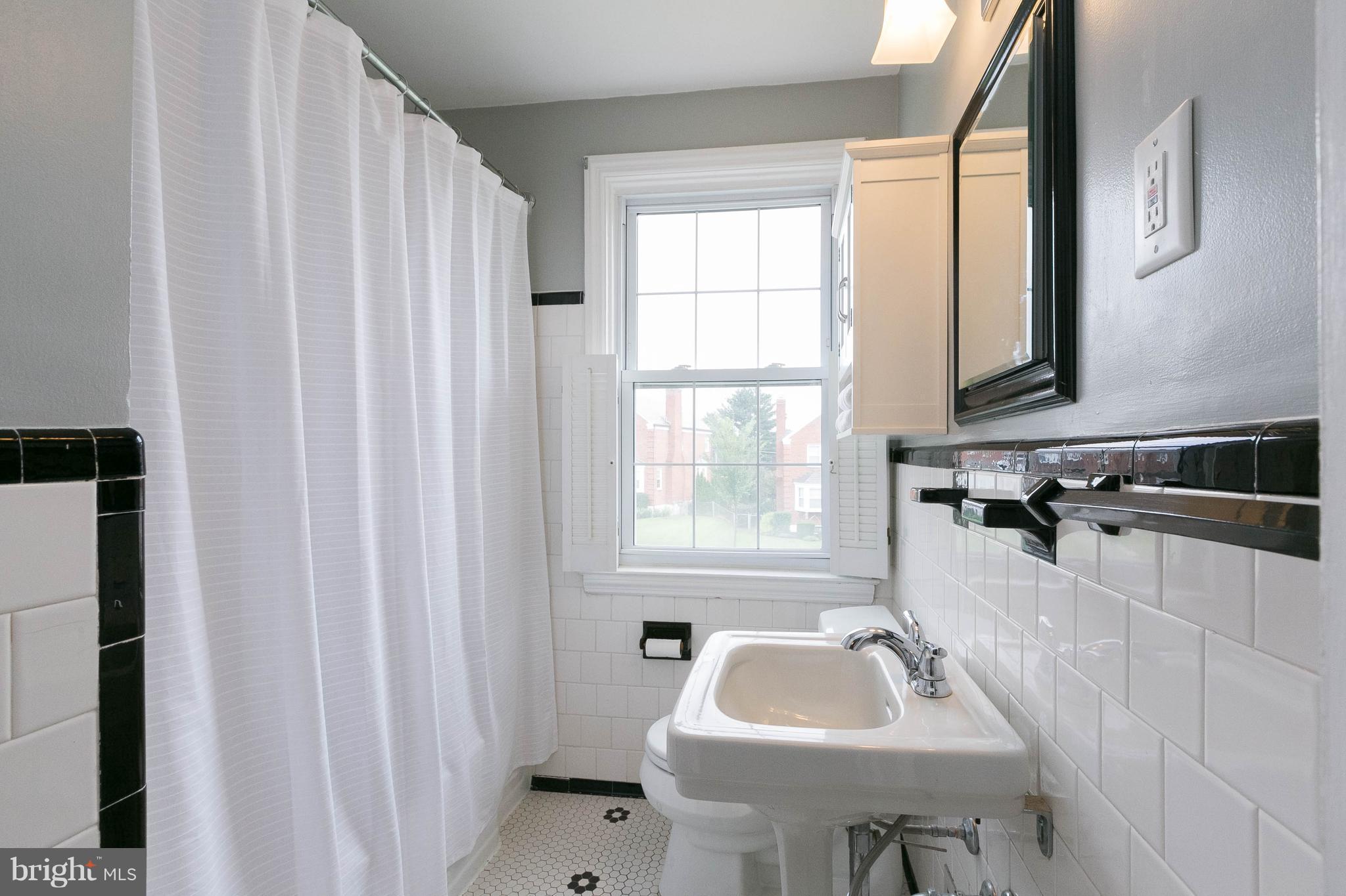 344 Greenlow Road Baltimore, MD 21228 - Photo 17 of 27 a bathroom with a sink a window and a mirror