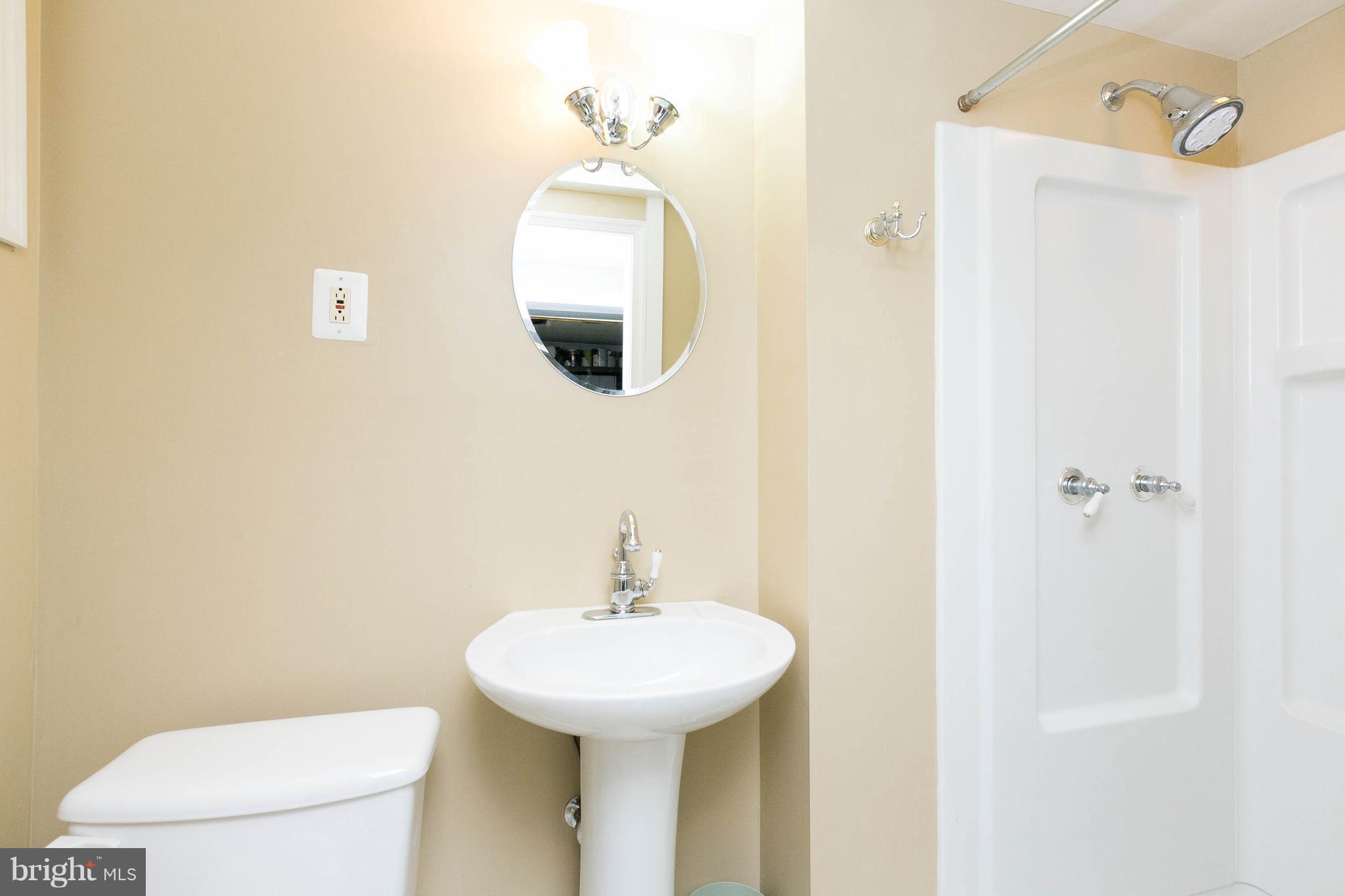 344 Greenlow Road Baltimore, MD 21228 - Photo 24 of 27 a bathroom with a sink and mirror with toilet
