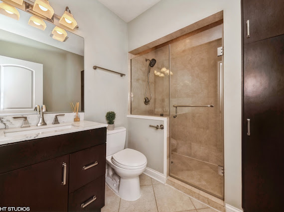 1347 West Fillmore Street, Unit A1 Chicago, IL 60607 - Photo 12 of 21 a bathroom with a toilet a sink a mirror and shower