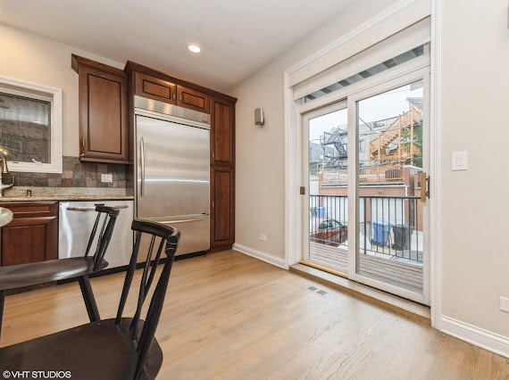 1347 West Fillmore Street, Unit A1 Chicago, IL 60607 - Photo 6 of 21 a kitchen with stainless steel appliances wooden floor and a refrigerator