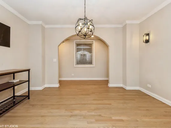 a view of an empty room with window and wooden floor