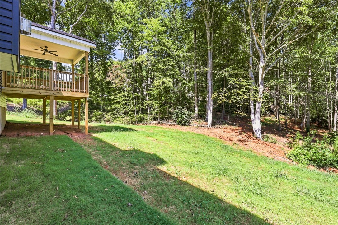 216 West Halfway Branch Road Walhalla, SC 29691 - Photo 28 of 41 Mature trees frame a grassy lawn bordering a raised wooden deck with a covered pavilion.