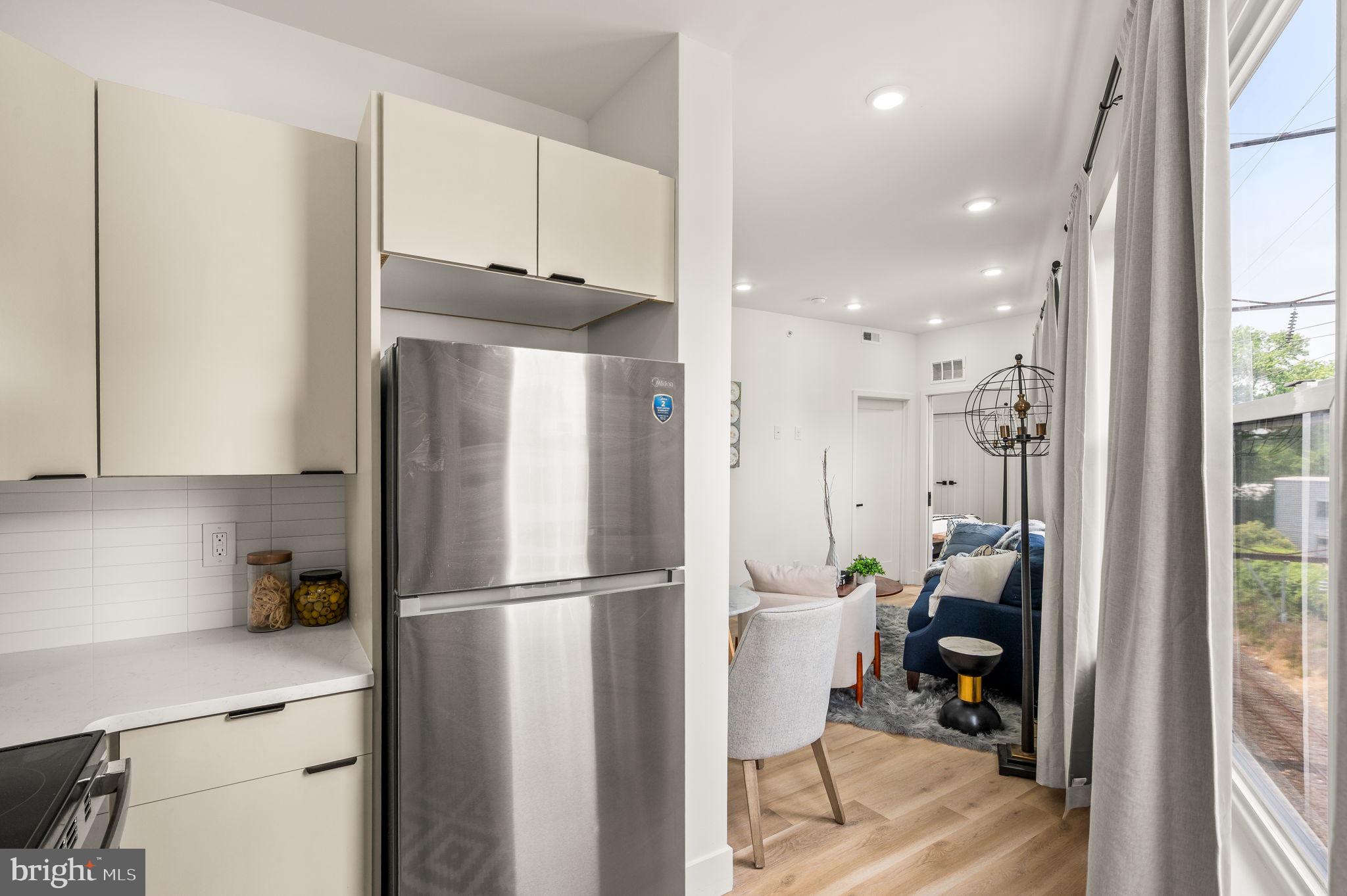 4921 Chester Avenue, Unit 2O2 Philadelphia, PA 19143 - Photo 7 of 10 a kitchen with stainless steel appliances granite countertop a refrigerator and a stove top oven