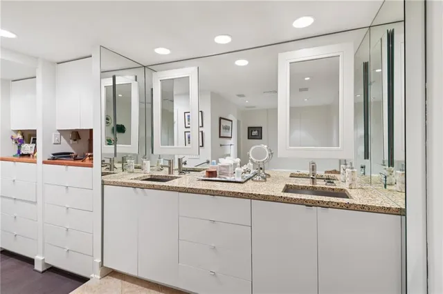 a bathroom with double vanity sinks and a mirror