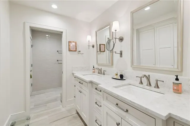a bathroom with double vanity sink a mirror and a shower