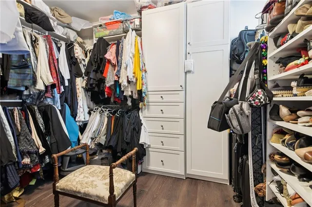 a view of walk in closet with clothes and shoes