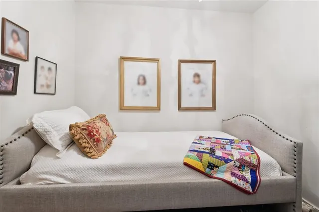 a bedroom with a bed and painting on the wall