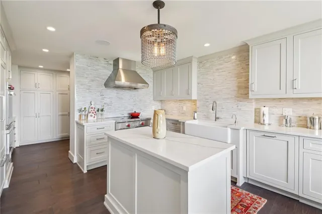 a kitchen with stainless steel appliances a sink a stove a refrigerator cabinets and a window