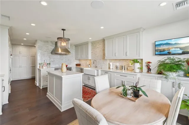 a kitchen with stainless steel appliances kitchen island granite countertop a white table and chairs