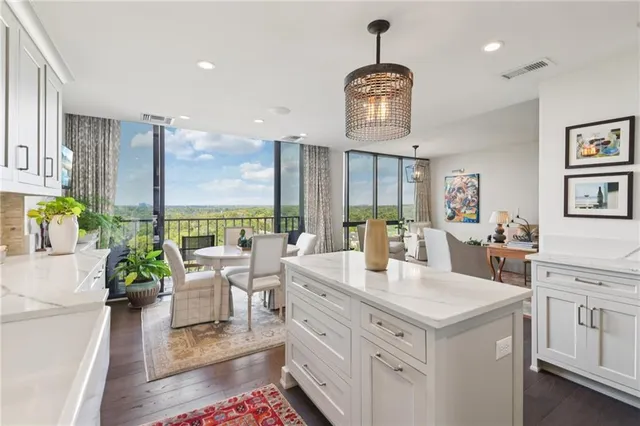a view of center island of a kitchen with granite countertop living room and living room