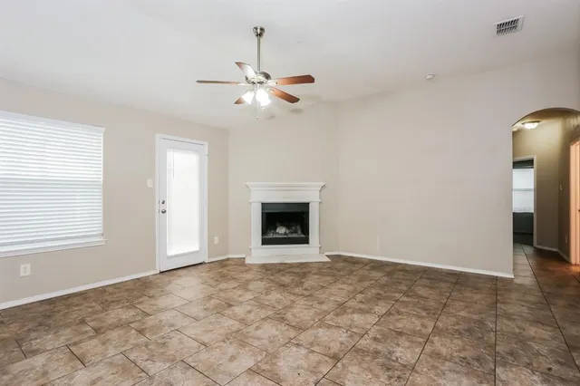 an empty room with windows and fireplace