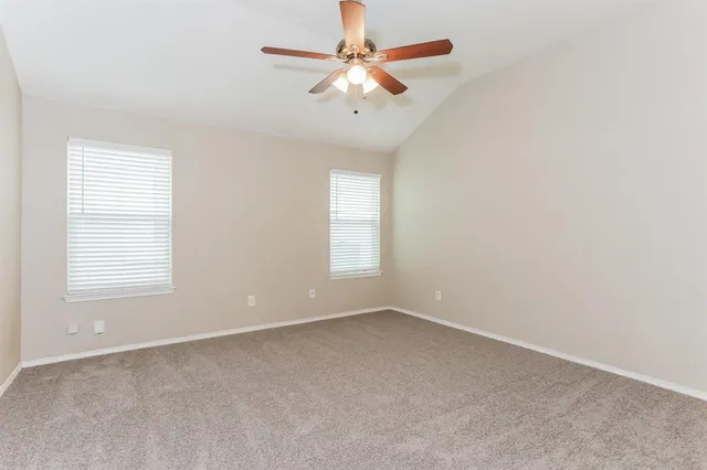 an empty room with a window and a fan