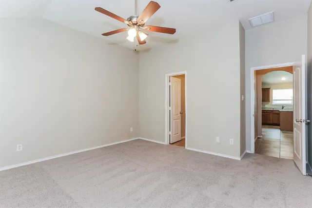 an empty room with fan and entrance