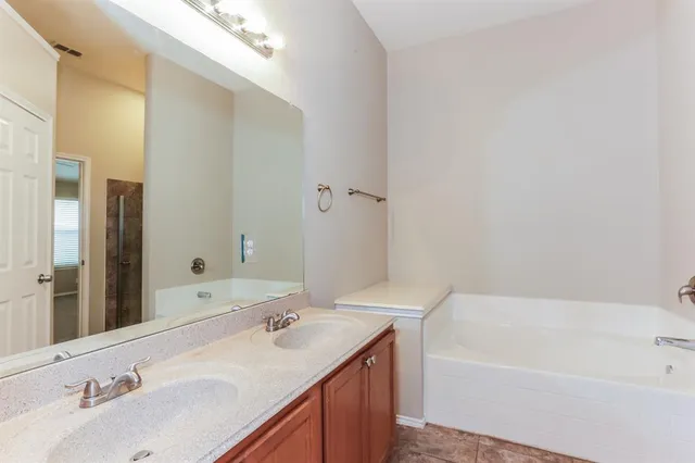 a bathroom with a tub sink and mirror