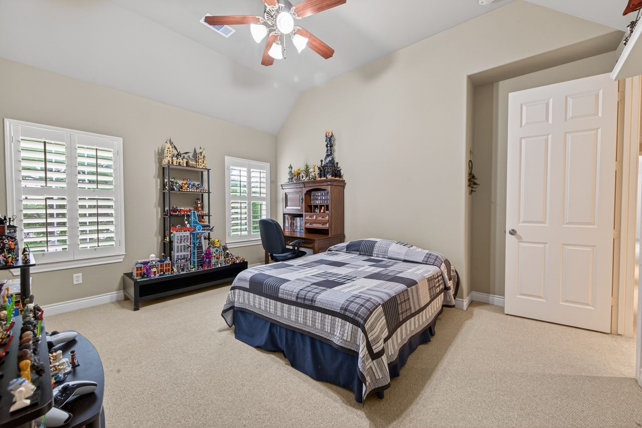 10932 Lasso Lane Houston, TX 77079 - Photo 22 of 38 a bedroom with a bed and a chandelier