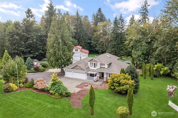 a front view of a house with a garden and trees