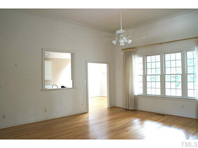 7624 Wilderness Road Raleigh, NC 27613 - Photo 8 of 25 a view of an empty room with wooden floor and a window