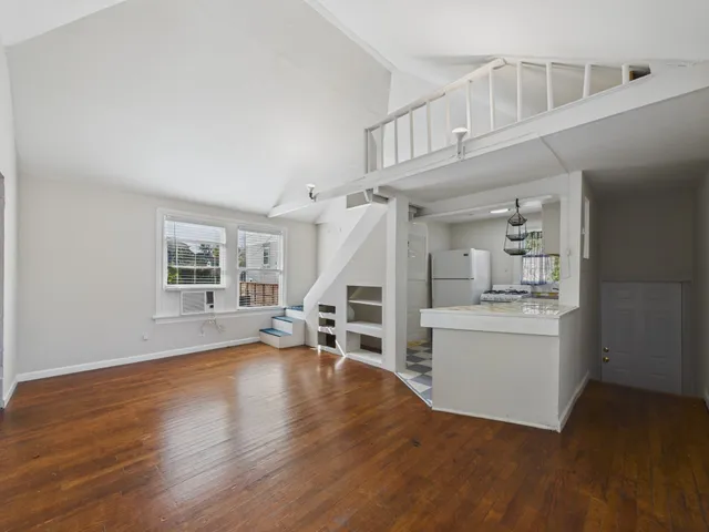 a view of empty room with wooden floor and fireplace