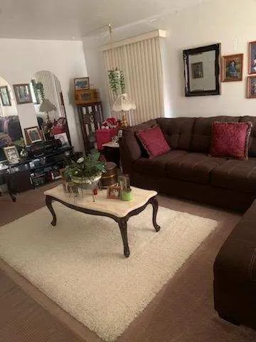 a living room with furniture a window and a flat screen tv