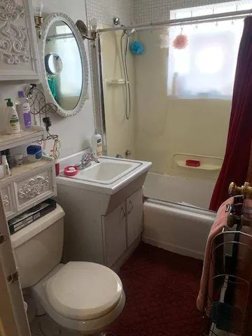 a bathroom with a toilet sink vanity tub and mirror