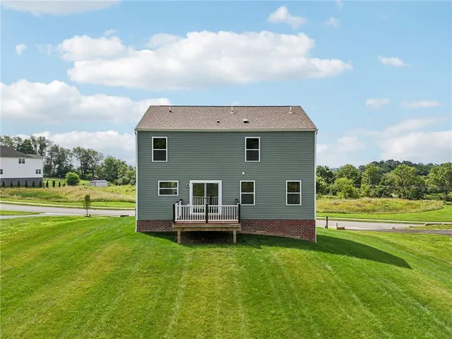 a front view of house with yard and car parked