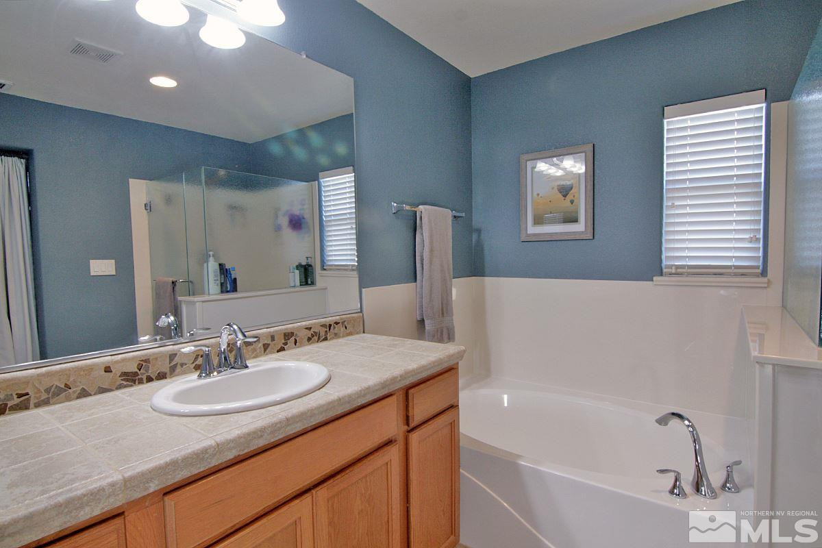 1910 Bears Ranch Drive Reno, NV 89521 - Photo 13 of 20 a bathroom with a granite countertop sink mirror and a bathtub