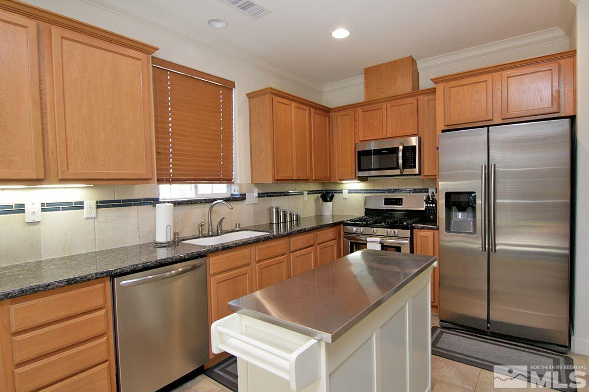 1910 Bears Ranch Drive Reno, NV 89521 - Photo 5 of 20 a kitchen with stainless steel appliances granite countertop a sink a stove a refrigerator cabinets and a counter top space