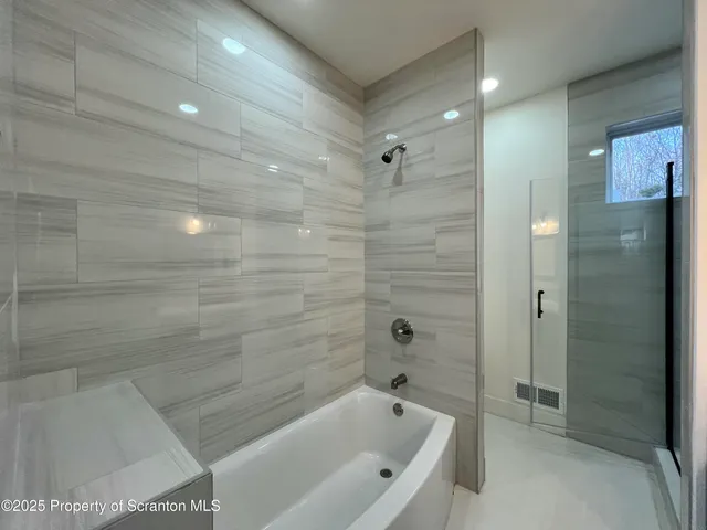 a bathroom with a bathtub and a shower