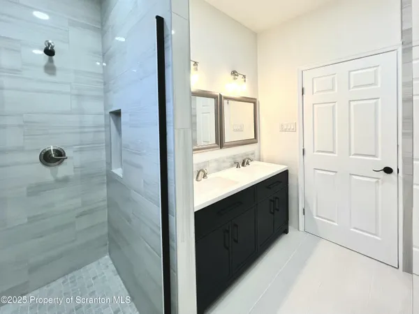 a bathroom with a double vanity sink a mirror and shower