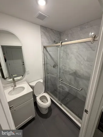 a bathroom with a sink mirror vanity and toilet