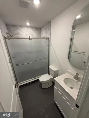 a bathroom with a sink mirror vanity and toilet