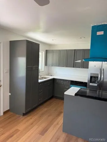 a kitchen with granite countertop a refrigerator and a stove top oven