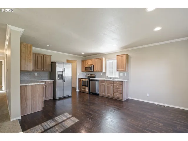 a kitchen with a refrigerator and white cabinets