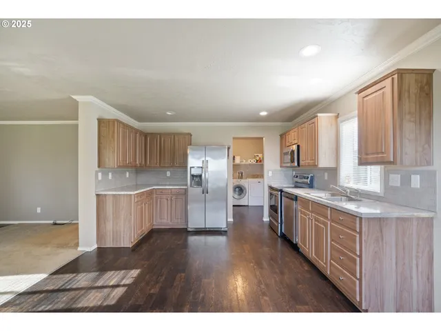 a kitchen with stainless steel appliances granite countertop a refrigerator a sink dishwasher a stove with wooden floor