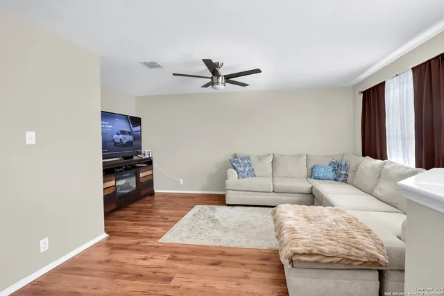 a living room with furniture a ceiling fan and a rug