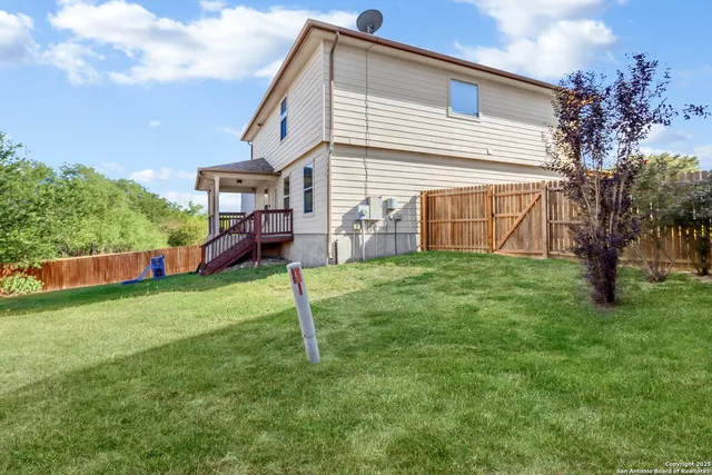 a view of a house with a backyard and a tree