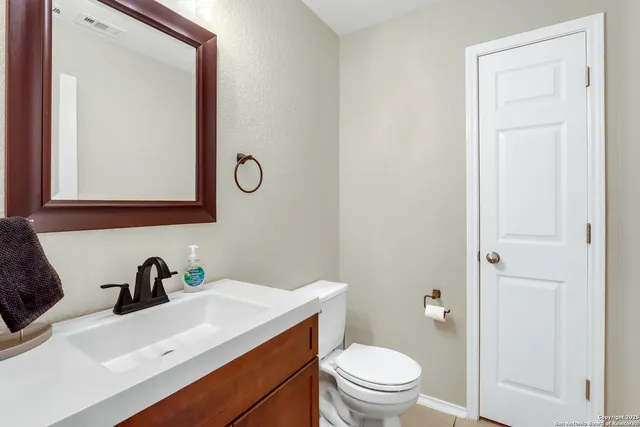 a bathroom with a toilet sink and mirror
