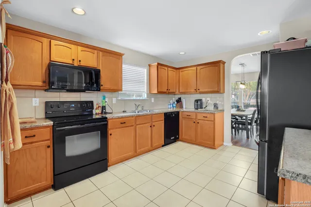 a kitchen with stainless steel appliances granite countertop a stove top oven a sink dishwasher a refrigerator and a microwave