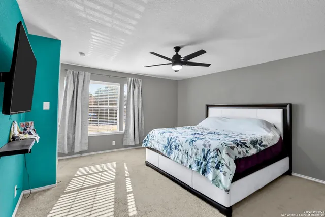 a bedroom with a large bed and a chandelier