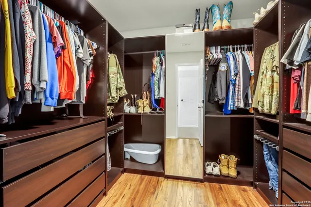 a view of walk in closet with clothes and shoes