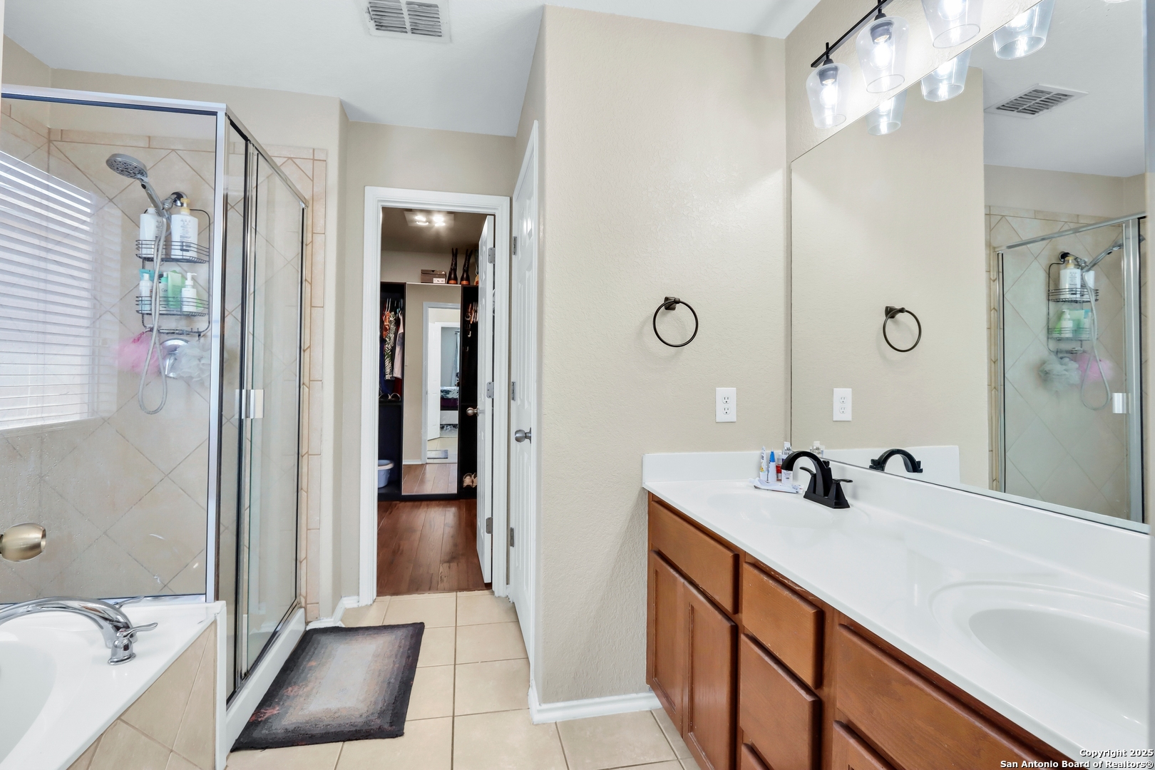 531 Erica Converse, TX 78109 - Photo 8 of 30 a en suite bathroom with a sink a mirror a bathtub and shower